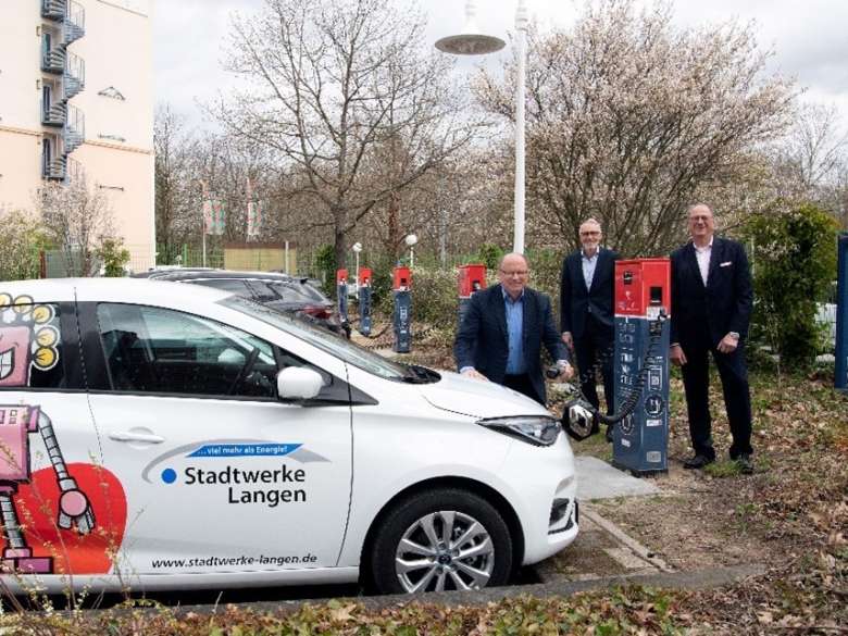 Seite an Seite beim Ausbau der öffentlichen  E-Ladein¬frastruktur: Die beiden Stadtwerke-Geschäftsführer Manfred Pusdrowski (links) und Uwe Linder (rechts) freuen sich mit Frank Metje (DFS, Lei-ter Niederlassung Campus Langen in Vertretung des Geschäftsführers Technik Friedrich-Wilhelm Menge) über die neuen Ladesäulen auf dem öffentlich zugäng-lichen Parkplatz der DFS Deutsche Flugsicherung im Wirtschaftszentrum Neurott. 			Foto: DFS
