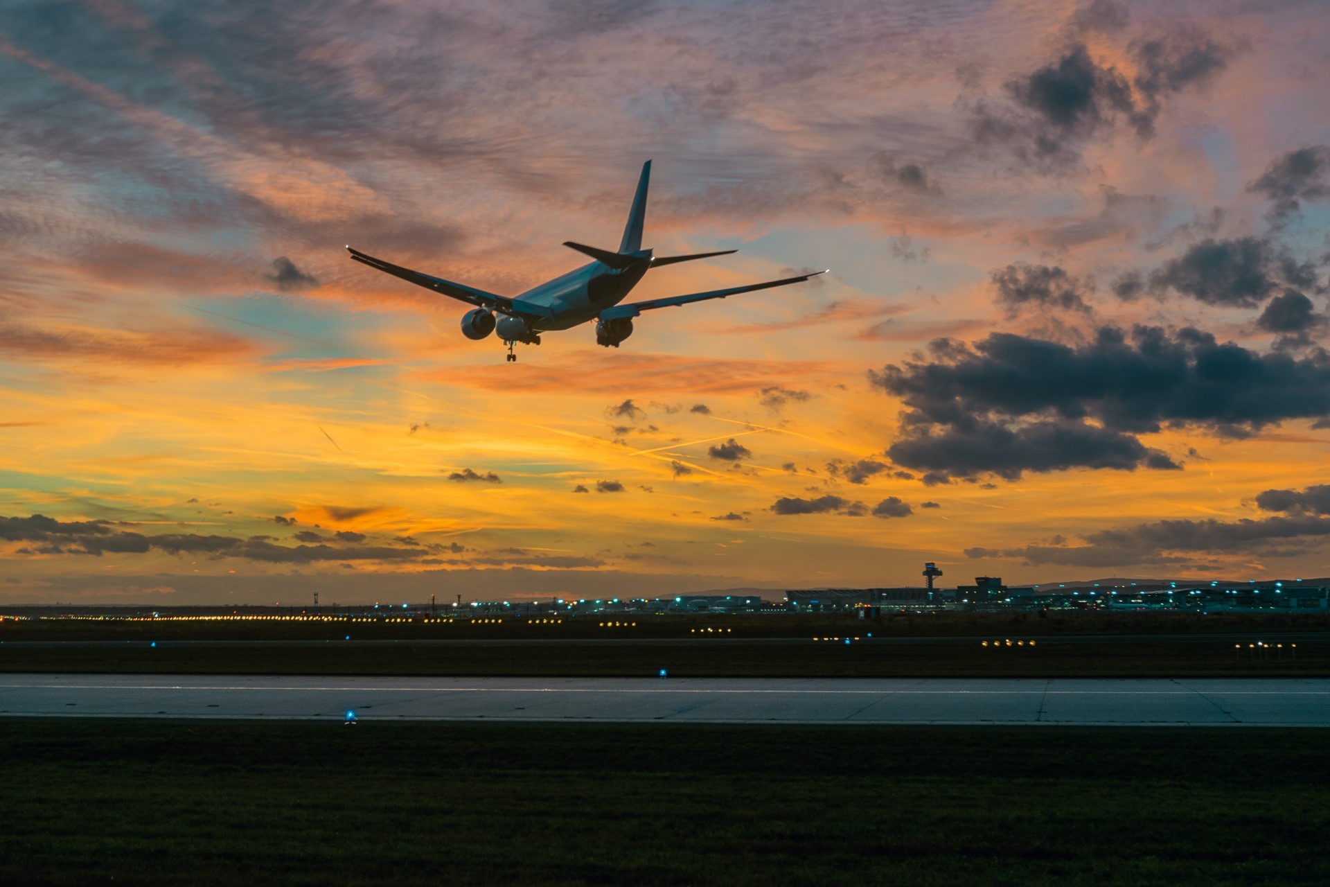 Ein Flugzeug landet am Frankfurter Flughafen vor bewölktem Himmel.