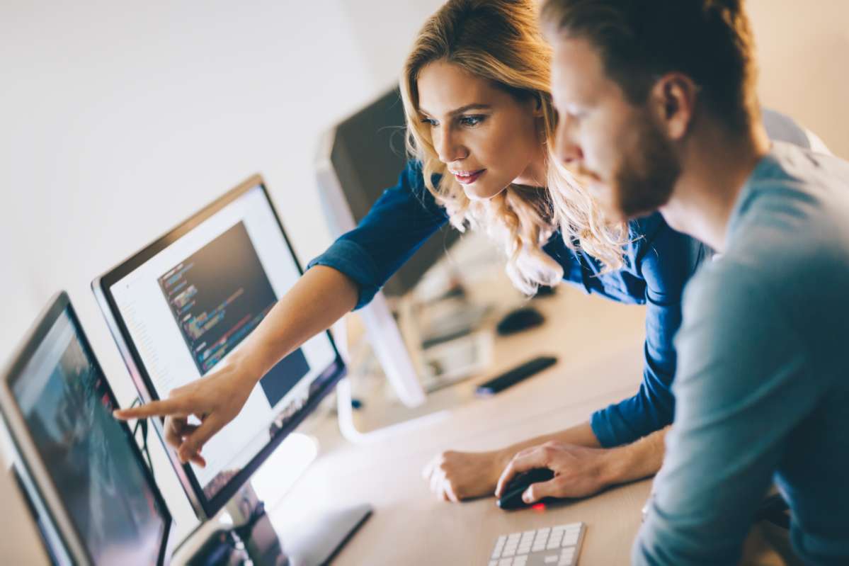 two persons in front of a monitor two persons in front of a monitor