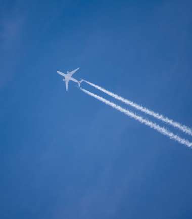 Flugzeug mit Kondensstreifen am Himmel